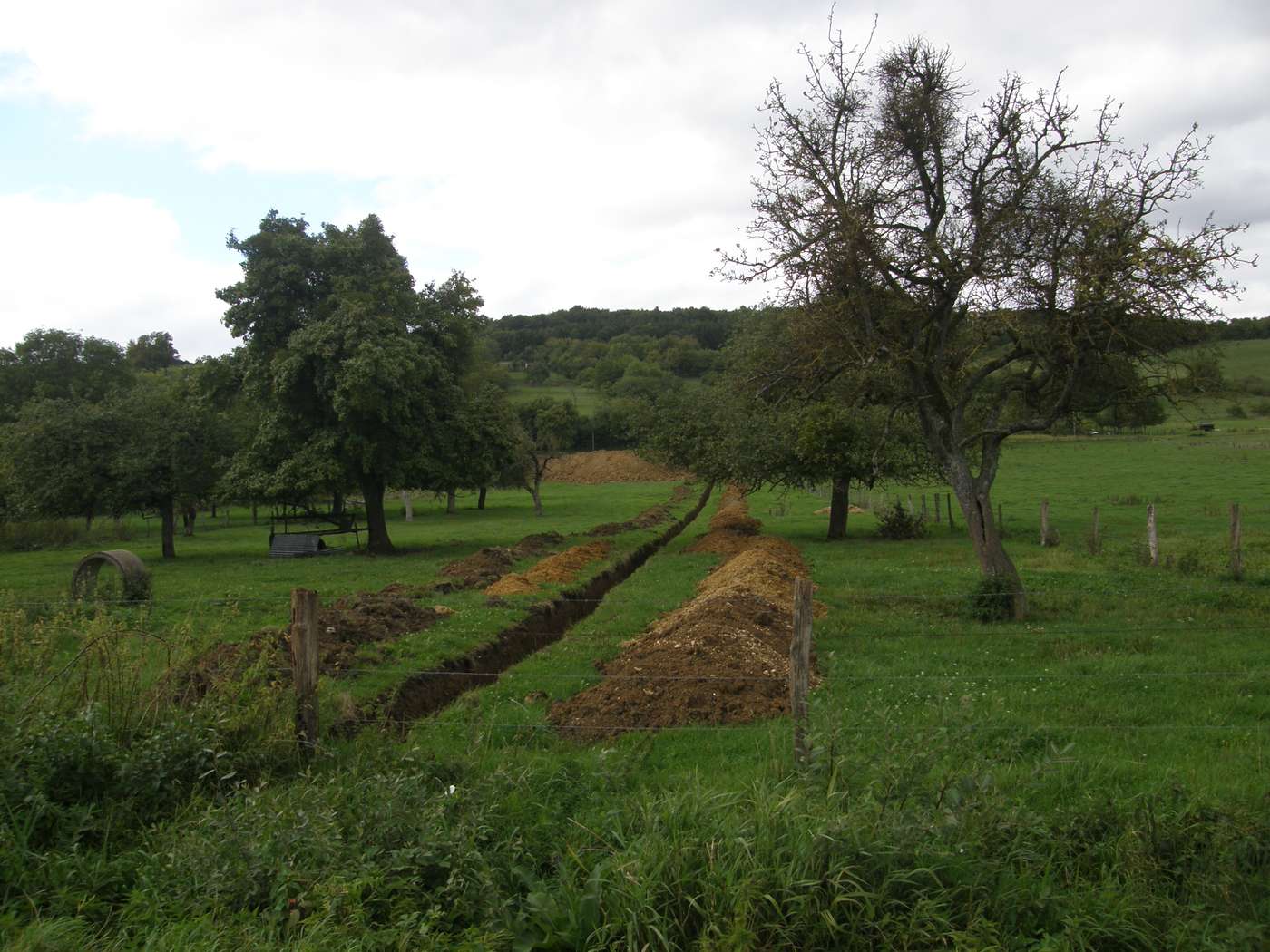 Pré à la campagne avec des tranchées fraîchement creusées pour un assainissement non collectif
